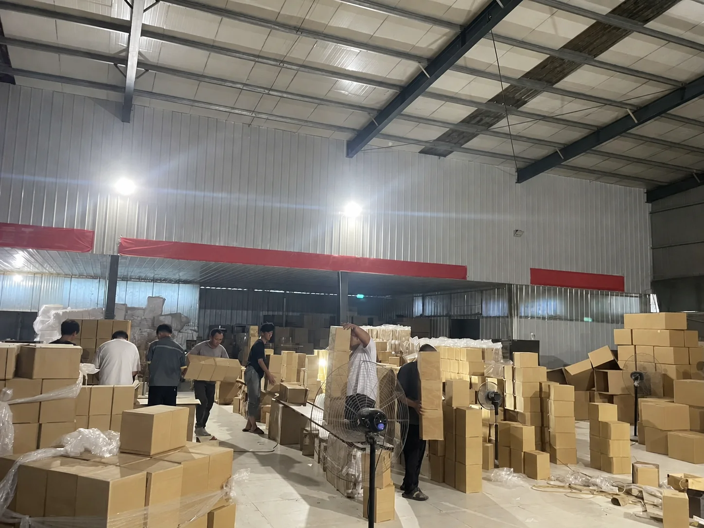 Unbranded factory packing area with workers preparing wood products for shipment