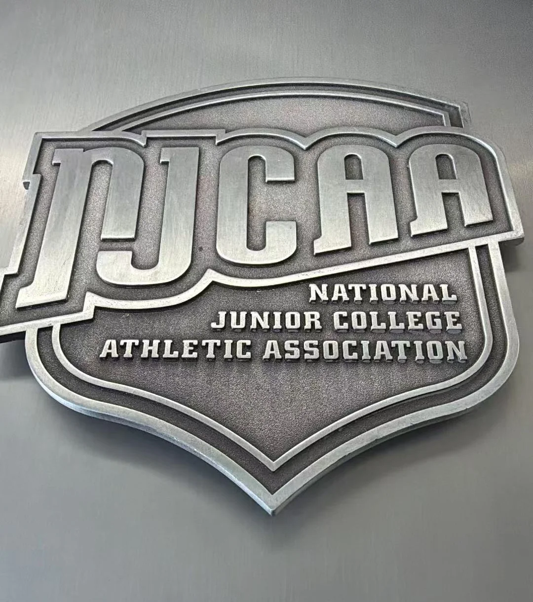 NJCAA dimensional metal emblem used with custom wood trophy components