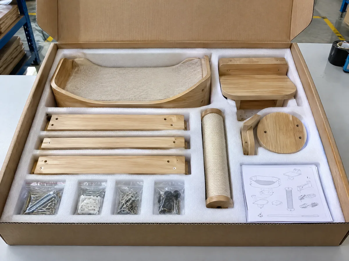 Unbranded disassembled wood cat wall furniture modules protected by custom EPE foam inside a corrugated carton