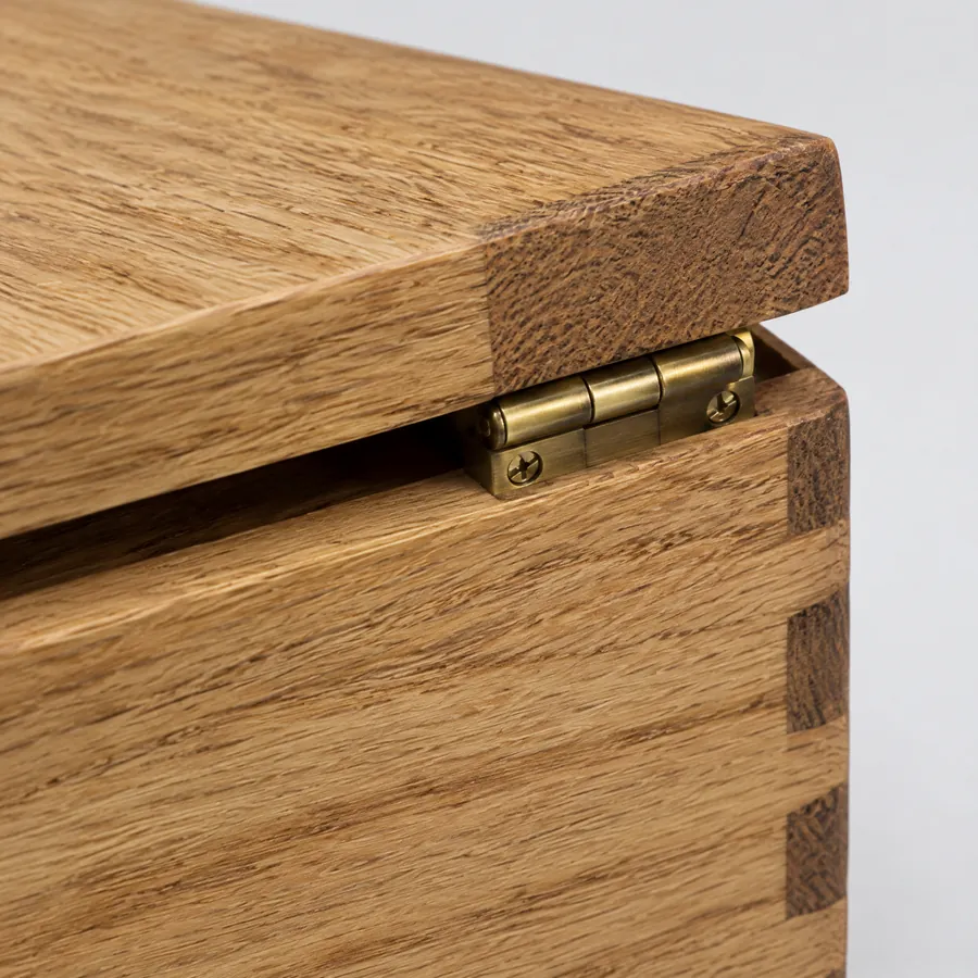 Compact metal hinges on a wooden presentation box